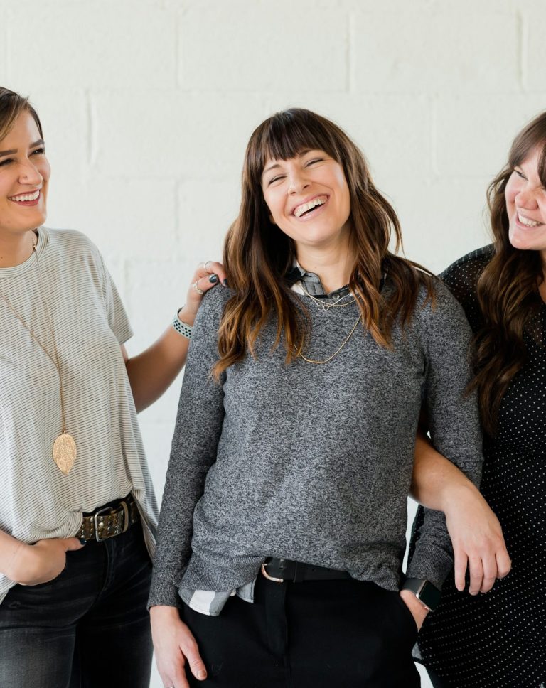 Drei Frauen lachen in die Kamera